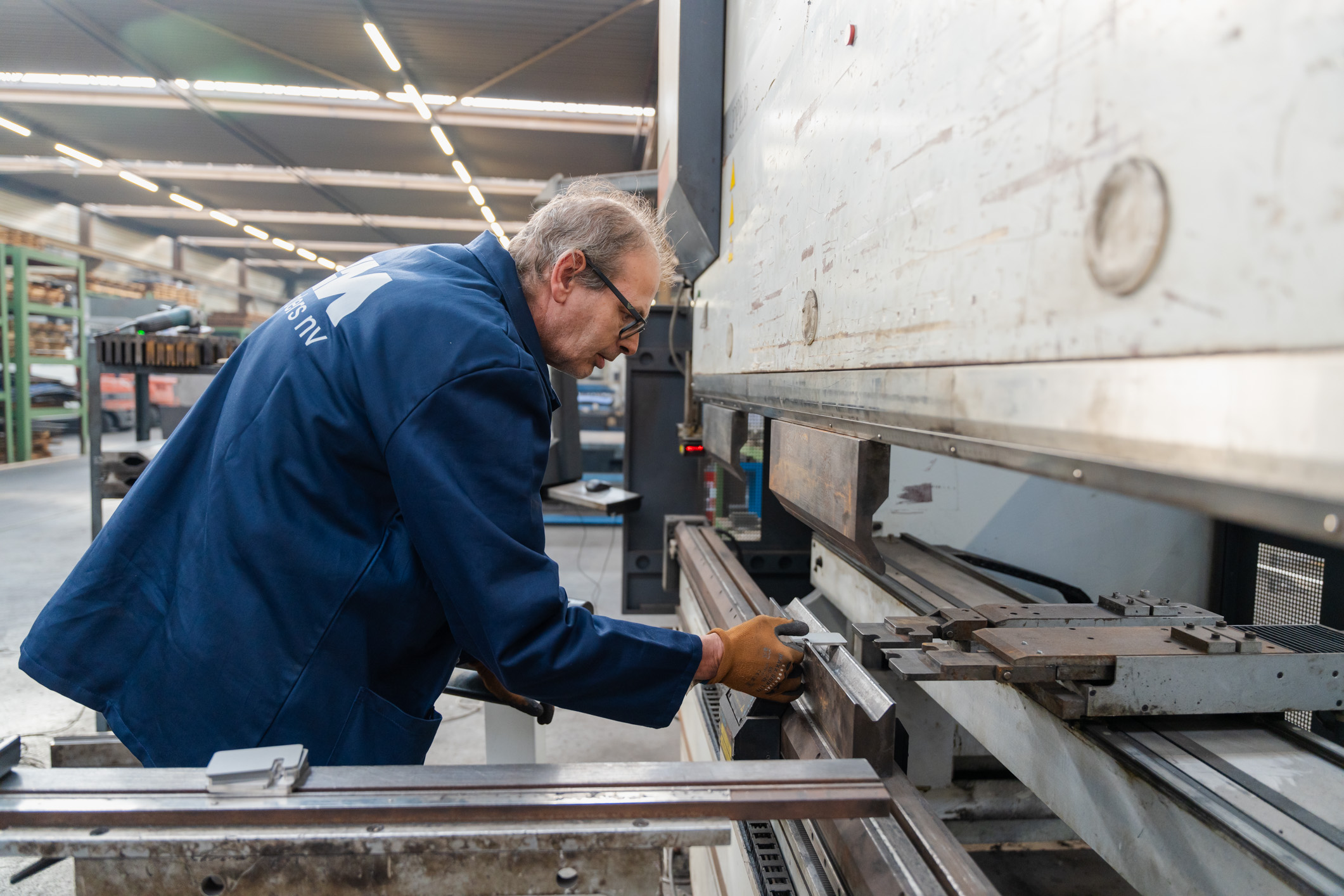 Een specialist van Leenders werkt met een machine.