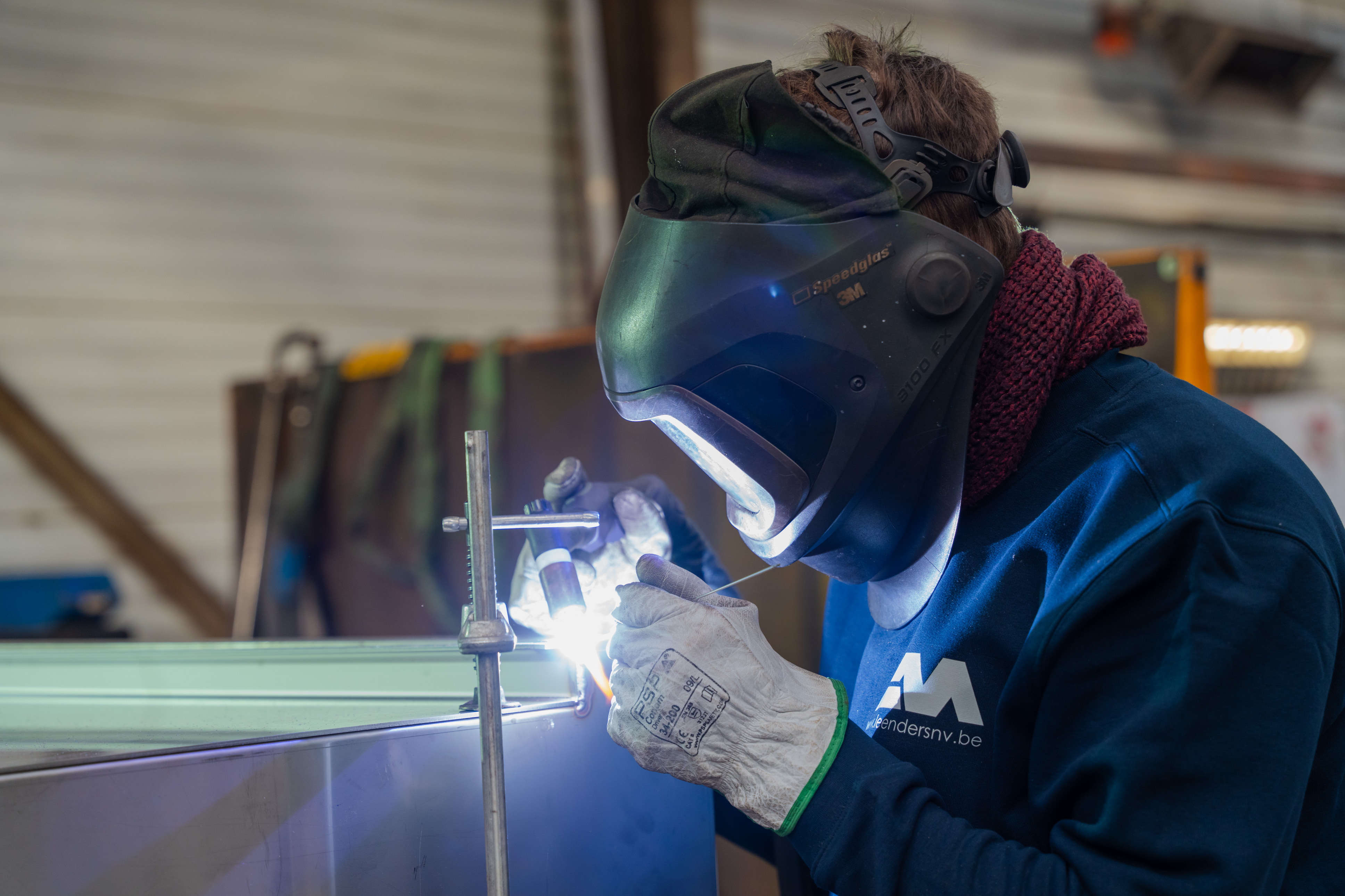 Lasser met helm die detail werk aan het lassen is.